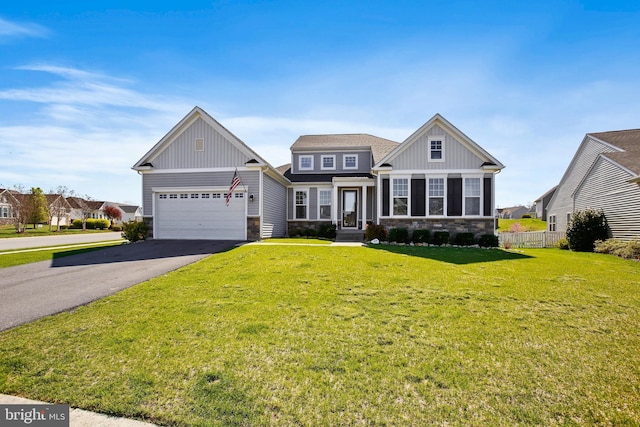 craftsman-style house with board and batten siding, driveway, stone siding, and a front lawn