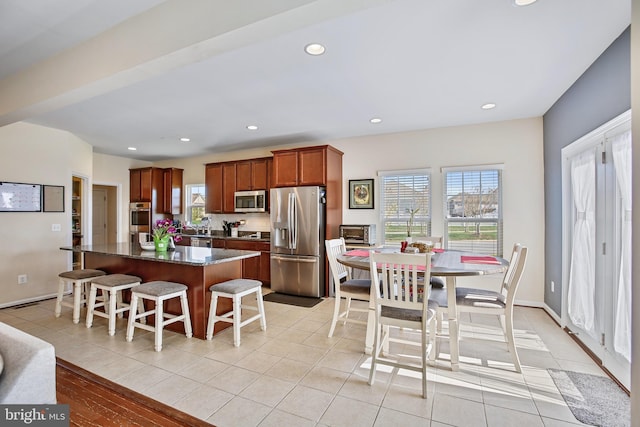 kitchen with plenty of natural light, a kitchen breakfast bar, stainless steel appliances, and a kitchen island
