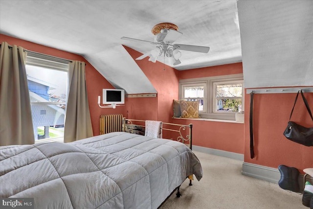 carpeted bedroom featuring vaulted ceiling, baseboards, a ceiling fan, and radiator