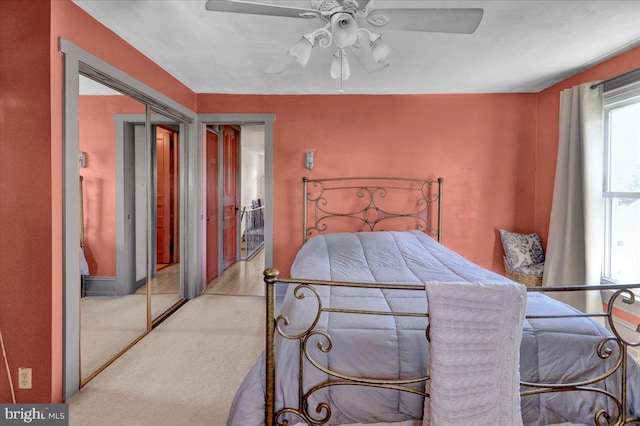 bedroom with a closet, ceiling fan, carpet flooring, and baseboards