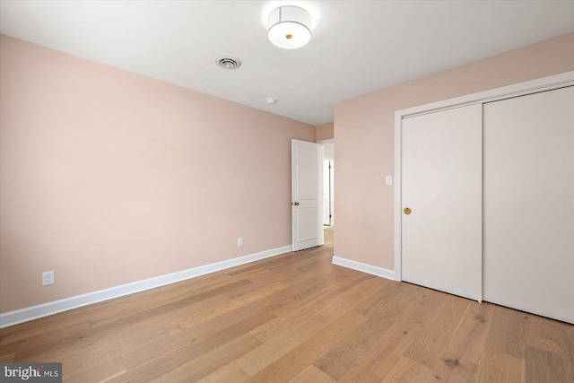 210 N Main St, Berlin, MD 21811 - unfurnished bedroom featuring light wood-style floors, baseboards, visible vents, and a closet