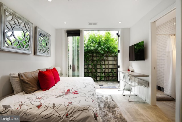 bedroom with access to outside, recessed lighting, wood finished floors, and visible vents