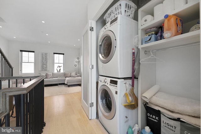 laundry room featuring laundry area, stacked washer and dryer, light wood finished floors, and recessed lighting