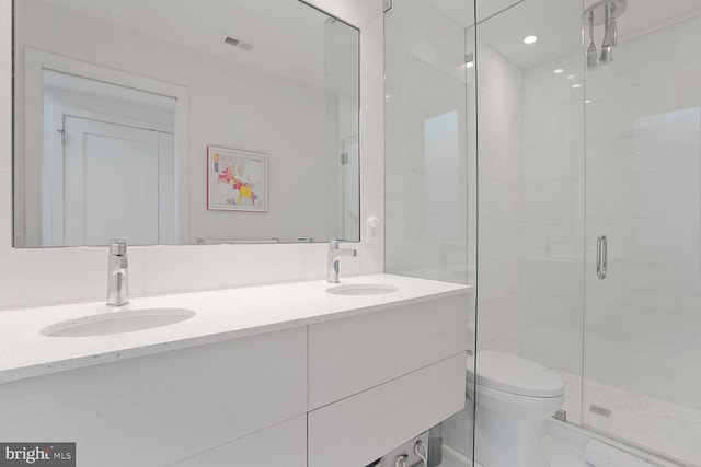bathroom featuring toilet, visible vents, a sink, and a stall shower