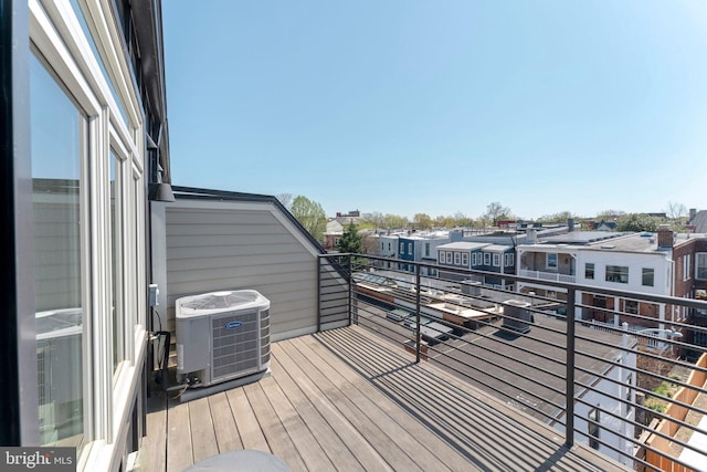 wooden terrace featuring central air condition unit and a residential view