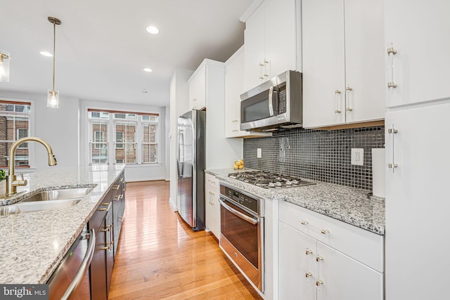 11350 Ridgeline Rd, Fairfax, VA 22030 - kitchen featuring a sink, white cabinets, light wood-type flooring, stainless steel appliances, and backsplash