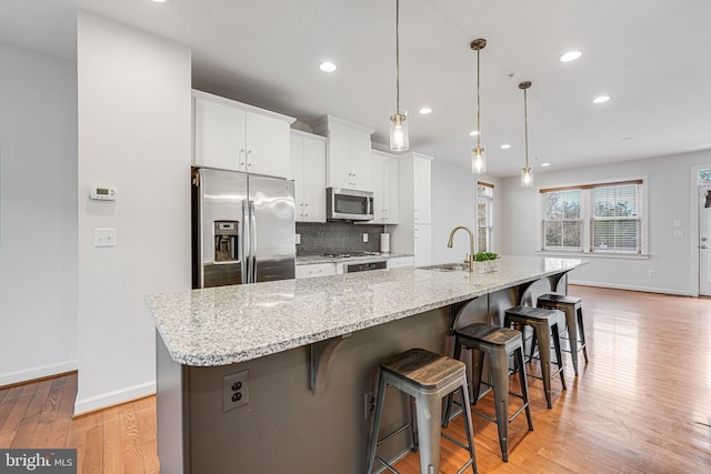 11350 Ridgeline Rd, Fairfax, VA 22030 - kitchen featuring stainless steel appliances, a large island, baseboards, light wood-style flooring, and tasteful backsplash
