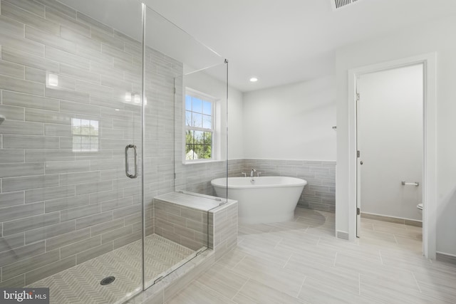 8504 Wendy St, Clinton, MD 20735 - full bathroom featuring tile walls, a stall shower, a soaking tub, tile patterned flooring, and toilet