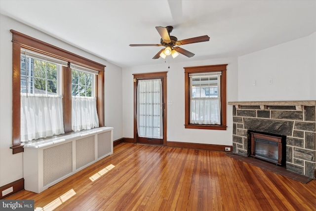 33 S Brighton Ave, Upper Darby, PA 19082 - unfurnished living room with ceiling fan, a stone fireplace, radiator heating unit, hardwood / wood-style floors, and baseboards