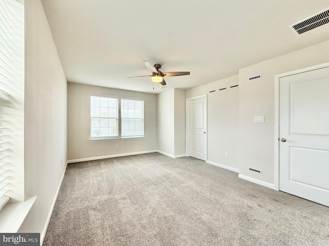 unfurnished bedroom featuring carpet, visible vents, baseboards, and a ceiling fan