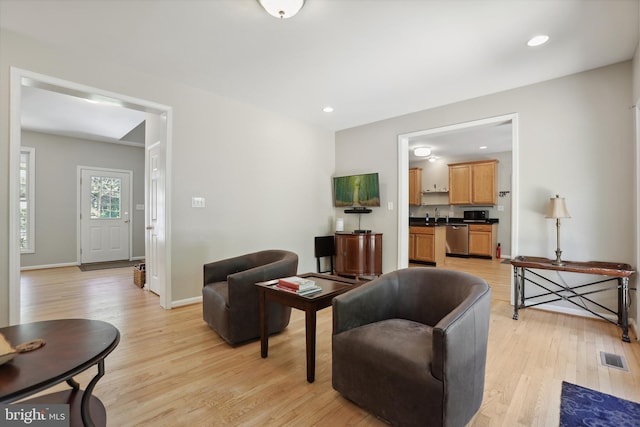 living area with recessed lighting, baseboards, visible vents, and light wood-style floors
