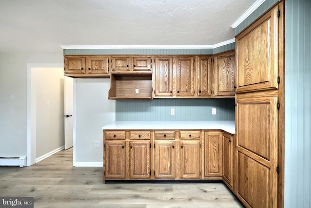 kitchen featuring baseboards, light countertops, light wood-style floors, baseboard heating, and brown cabinetry