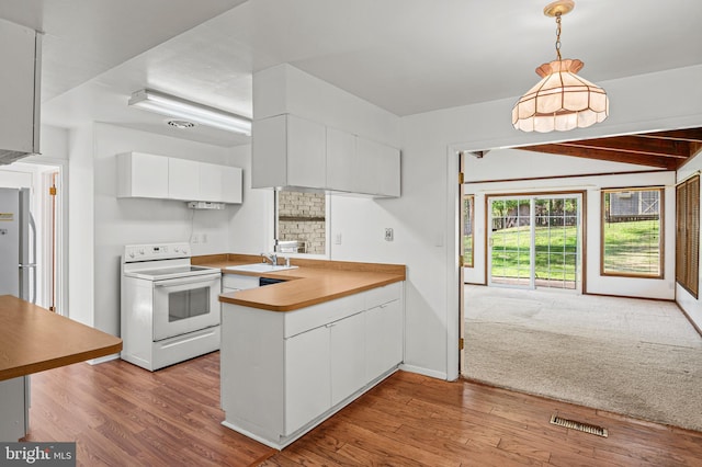 kitchen featuring visible vents, a peninsula, electric stove, white cabinetry, and wood finished floors