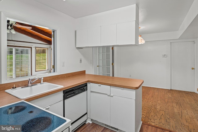 kitchen featuring white appliances, a peninsula, white cabinets, wood finished floors, and a sink