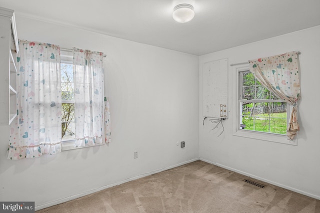 unfurnished room featuring baseboards, carpet, and visible vents