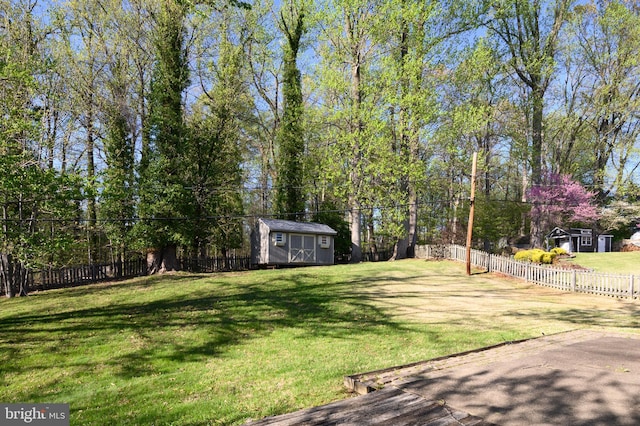 view of yard featuring a fenced backyard, an outdoor structure, and a shed