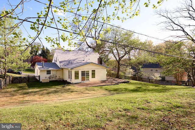 back of house featuring a yard, a fenced backyard, and a chimney