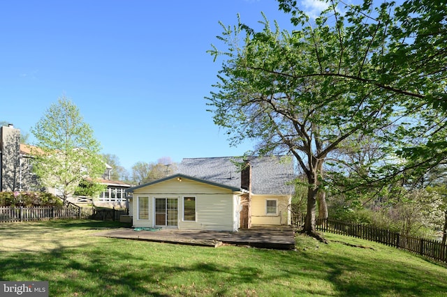 back of property featuring a yard, a fenced backyard, and a deck