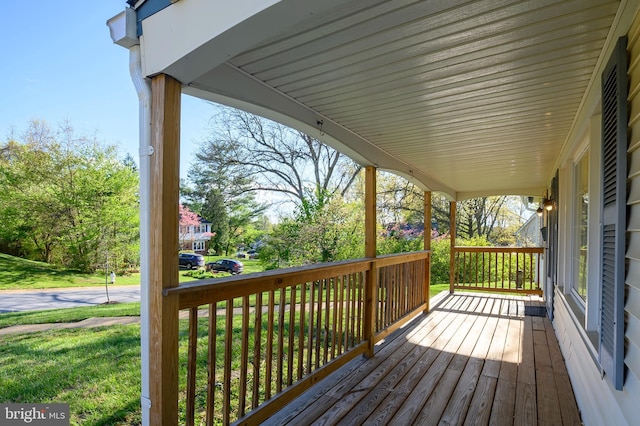 deck featuring a porch and a lawn
