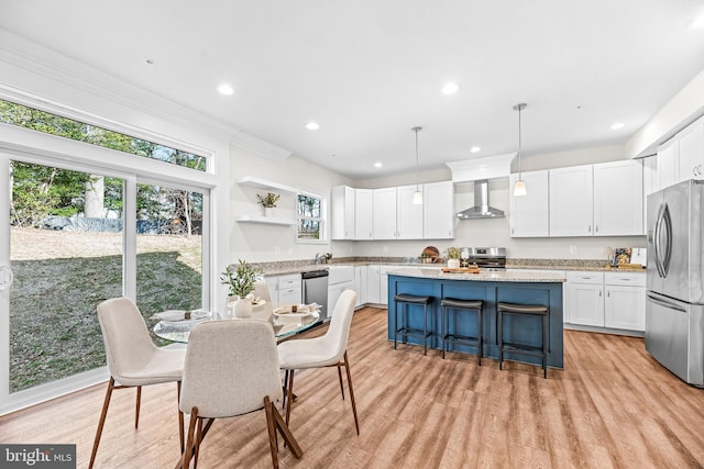 kitchen with a center island, open shelves, white cabinets, wall chimney exhaust hood, and stainless steel appliances