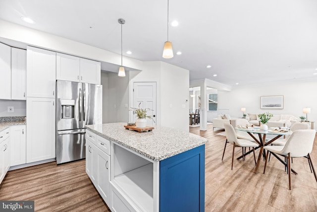kitchen with stainless steel fridge with ice dispenser, open floor plan, light wood-style floors, recessed lighting, and white cabinetry