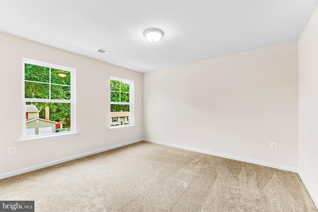 spare room with visible vents, baseboards, and carpet floors