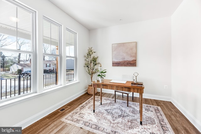 office with wood finished floors, baseboards, and visible vents