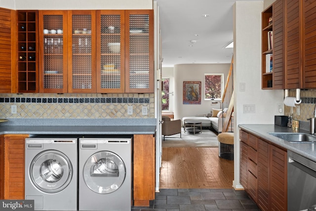 1910 Biltmore St NW Unit 2, Washington, DC 20009 - kitchen featuring washer and clothes dryer, a sink, dishwasher, decorative backsplash, and glass insert cabinets