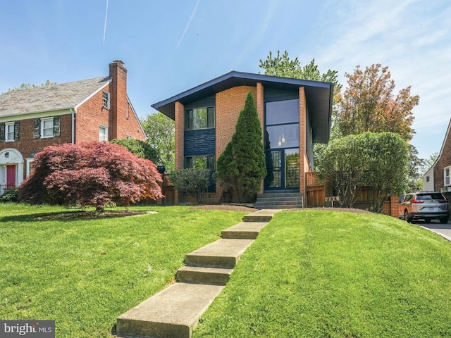 view of front of home with brick siding and a front lawn