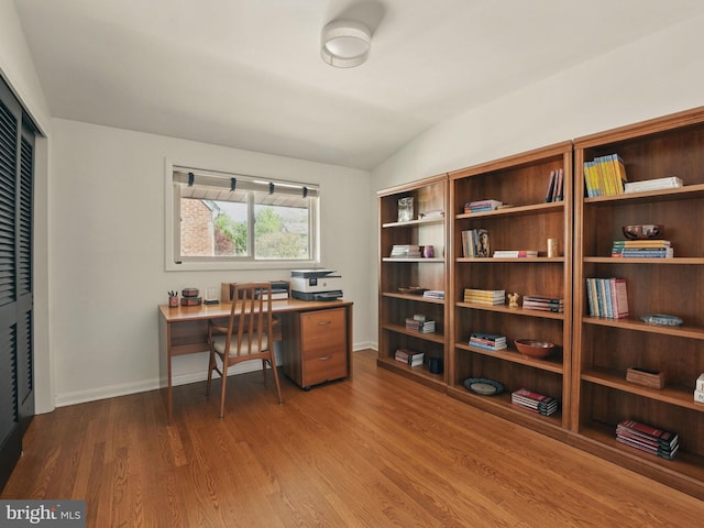 office space with baseboards, wood finished floors, and lofted ceiling