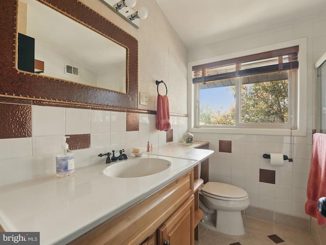 bathroom featuring visible vents, tile walls, vanity, tile patterned floors, and toilet