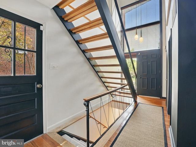 interior space with stairs, baseboards, and wood finished floors