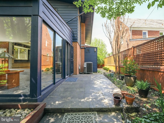 view of patio / terrace with cooling unit and a fenced backyard