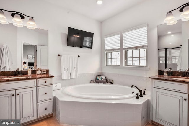 full bathroom featuring a bath, a stall shower, two vanities, and a sink