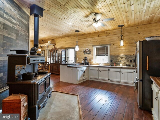 125 Rural Retreat Ln, Great Cacapon, WV 25422 - kitchen with a wood stove, freestanding refrigerator, dark wood-type flooring, a ceiling fan, and hanging light fixtures