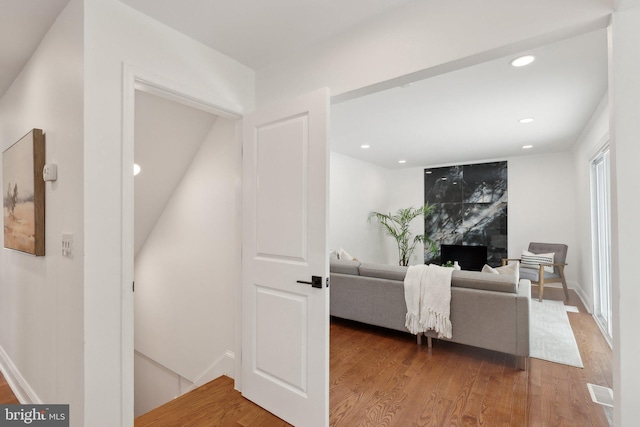 hall with baseboards, wood finished floors, and recessed lighting
