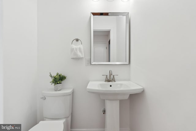 half bath with toilet and a sink