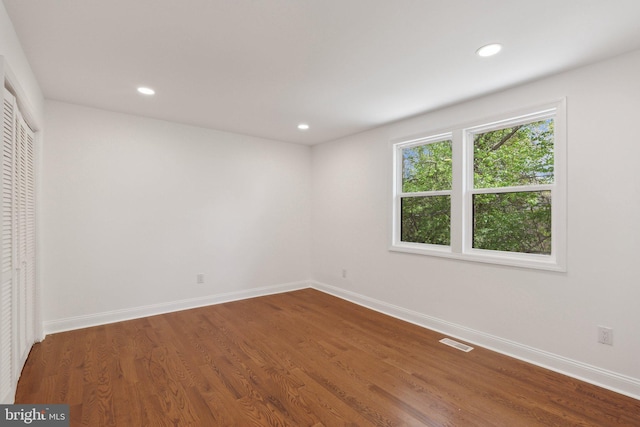 unfurnished bedroom featuring baseboards, wood finished floors, visible vents, and recessed lighting