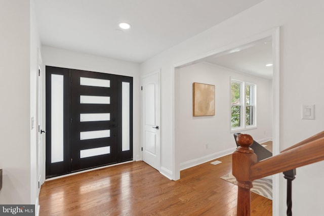 foyer with baseboards, wood finished floors, visible vents, and recessed lighting