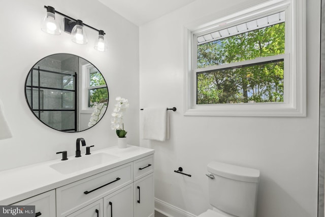 full bathroom with baseboards, vanity, an enclosed shower, and toilet