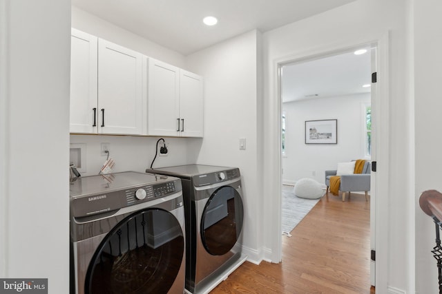 washroom with wood finished floors, cabinet space, washing machine and dryer, baseboards, and recessed lighting