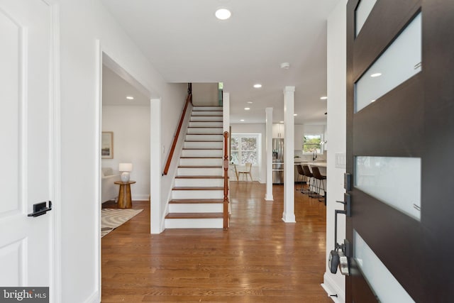 foyer entrance with baseboards, wood finished floors, recessed lighting, and stairway