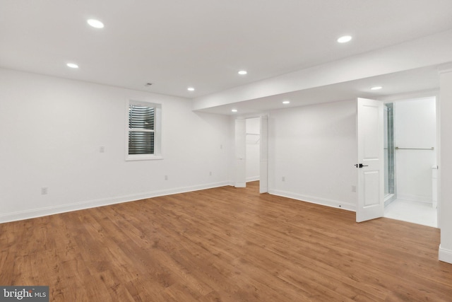 finished below grade area with baseboards, light wood finished floors, and recessed lighting