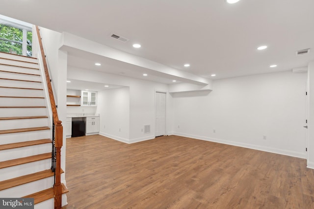 below grade area with recessed lighting, stairway, visible vents, and wood finished floors