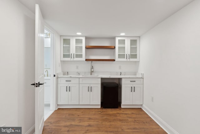 bar with recessed lighting, light wood-style flooring, baseboards, and a sink