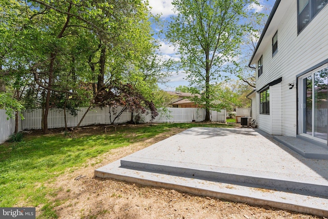 view of yard with a fenced backyard, central AC unit, and a patio area