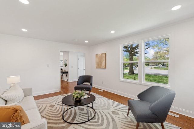living room with recessed lighting, wood finished floors, visible vents, and baseboards