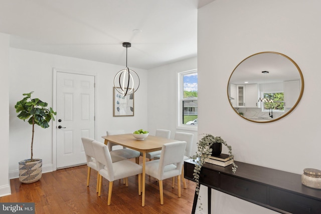 dining space with baseboards and wood finished floors