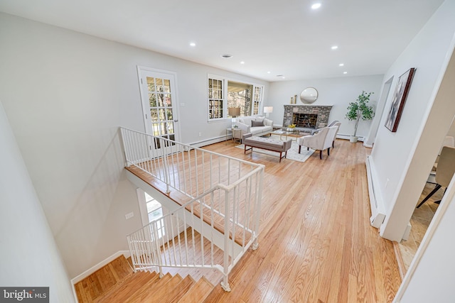 living area featuring light wood-style flooring, recessed lighting, and baseboard heating