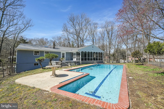 view of swimming pool with a fenced in pool, a patio, a fenced backyard, and a sunroom